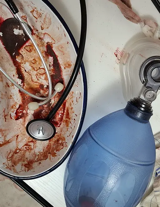 Auf dem Bild ist eine Schüssel, wo man Blut sehen kann. in der Schüssel liegt ein Stethoskop.